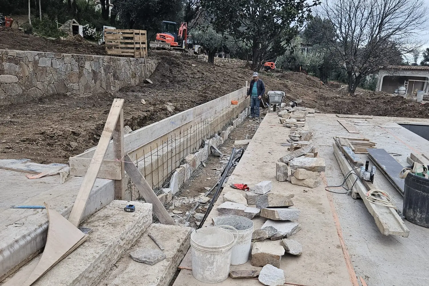 Coffrage et pose de pierre sur une dalle béton, chantier SP BAT