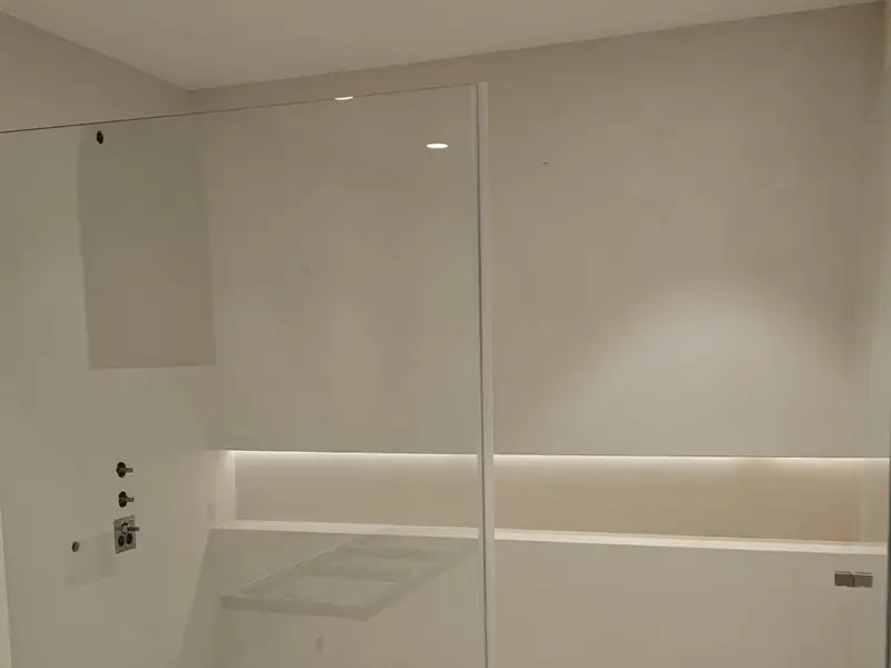 Douche à l’italienne en béton ciré avec niche éclairée et paroi en verre