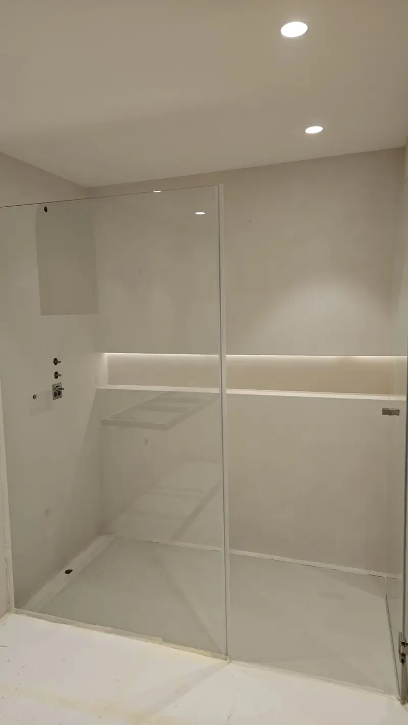 Douche à l’italienne en béton ciré avec niche éclairée et paroi en verre