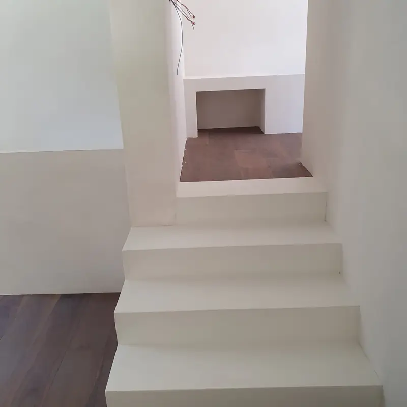 Escalier intérieur en béton ciré clair avec parquet en haut des marches
