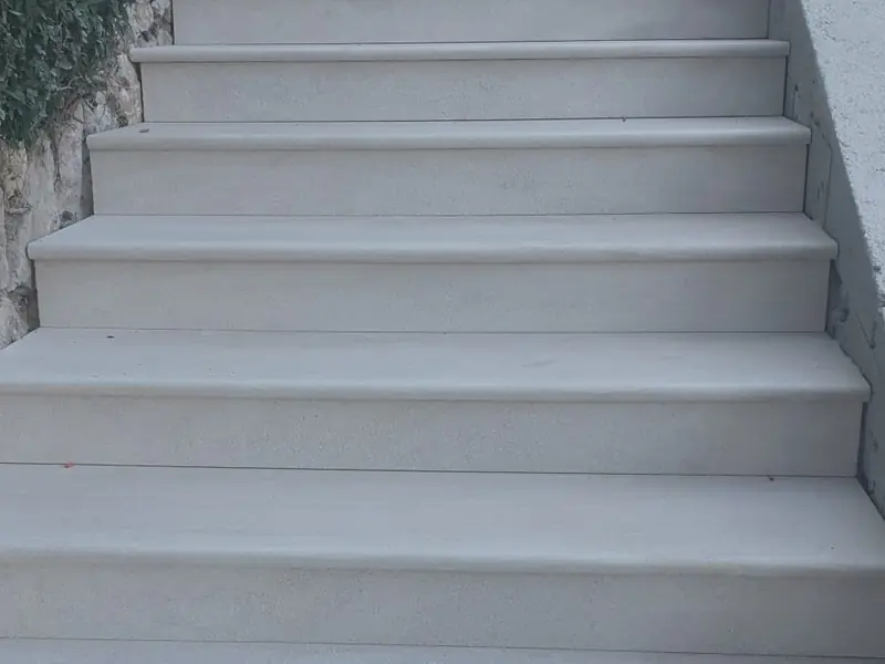 Escalier extérieur en béton fini, marches enduites en blanc