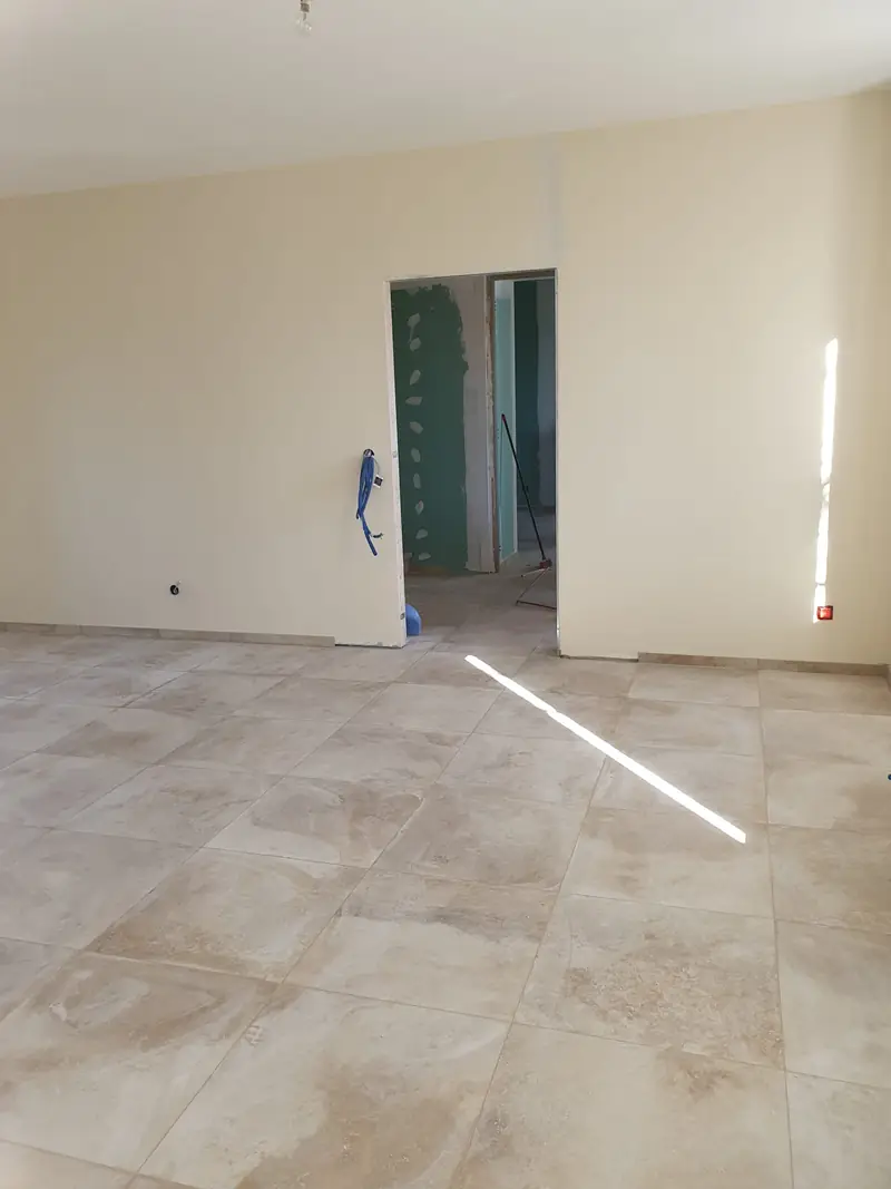 Pièce rénovée, carrelage posé et baie cintrée en cours de finition