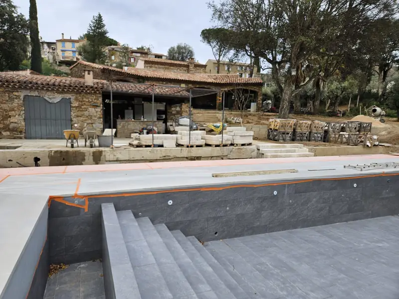 Bassin carrelé devant la bastide et sa cuisine d’été