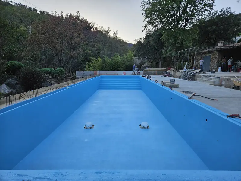 Grand bassin de piscine en béton après application de l’enduit d’étanchéité