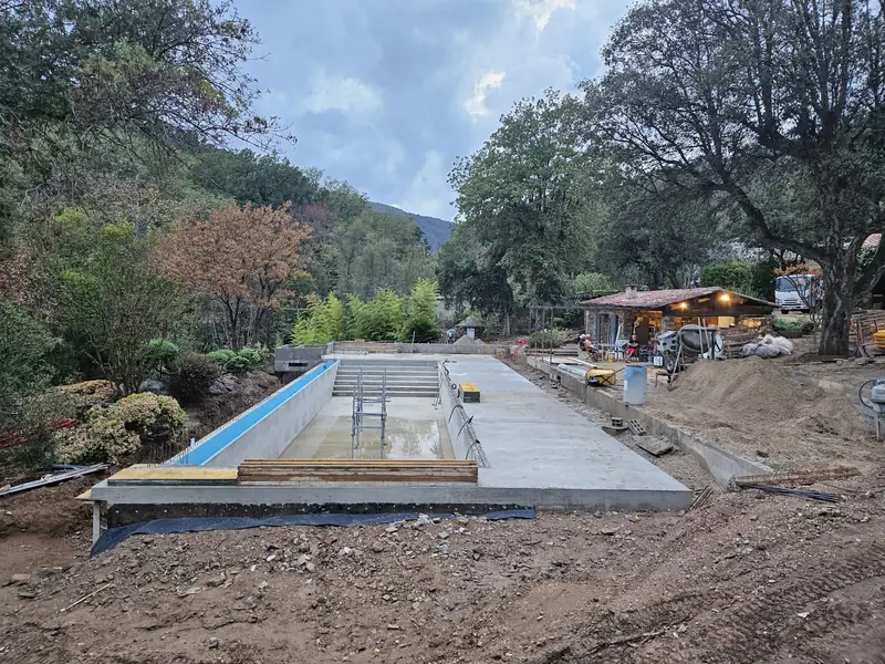 Bassin béton et plage coulée en fin de journée sur le chantier
