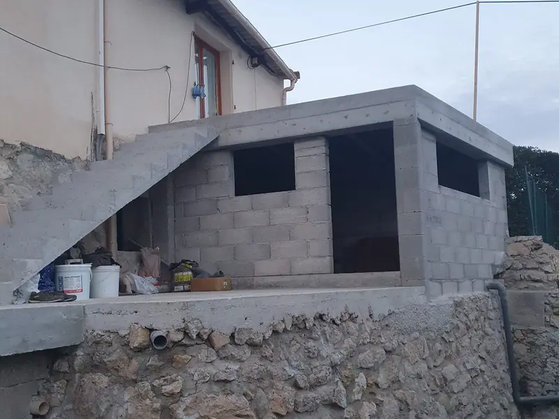 Local maçonné en blocs béton sur un soubassement en pierre