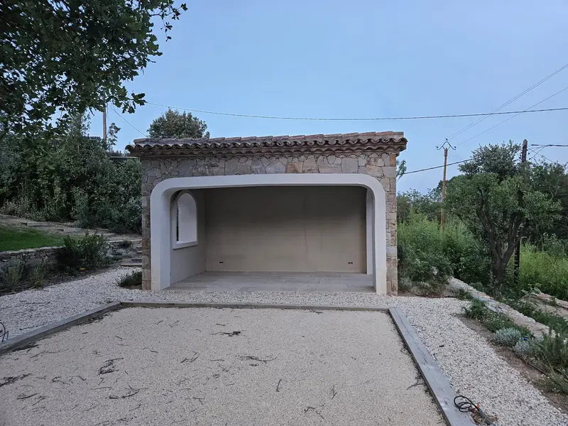 Pool house en pierre du pays avec arche enduite et toiture en tuiles