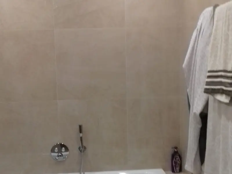 Baignoire encastrée et carrelage beige grand format