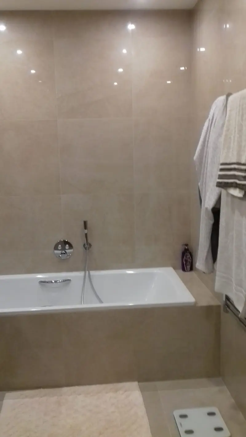 Baignoire encastrée et carrelage beige grand format