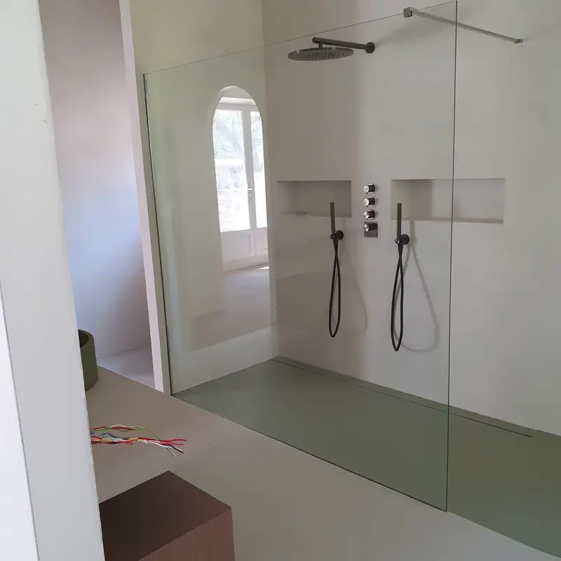 Douche à l’italienne en béton ciré vert d’eau avec niche et robinetterie noire