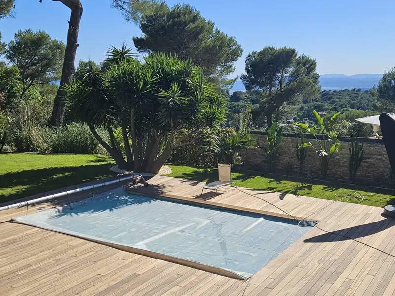 Piscine rénovée avec volet immergé et terrasse bois face à la mer