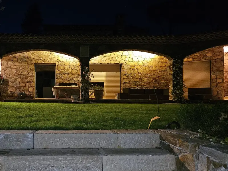 Façade en pierre à trois voûtes éclairées de nuit